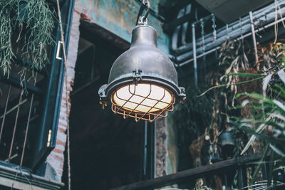 Low angle view of illuminated pendant light hanging from ceiling