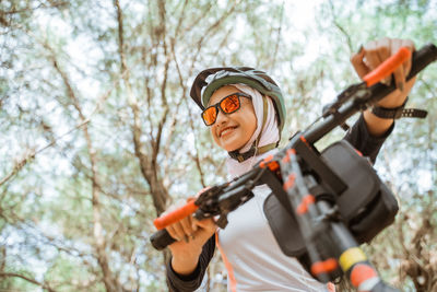 Low angle view of man holding camera