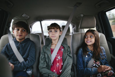 Siblings sitting side by side in car