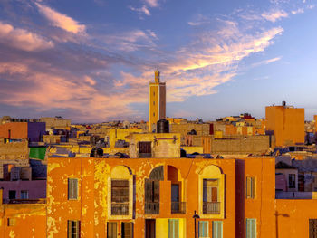 Buildings in city against sky during sunset