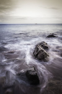 Rocks and flowing waves along the shoreline 