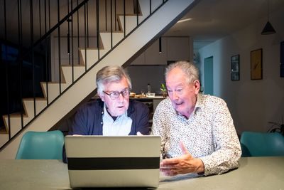 Portrait of senior man using mobile phone while sitting at home