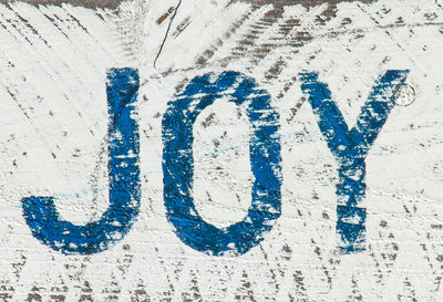 Close-up of painted text on white wall