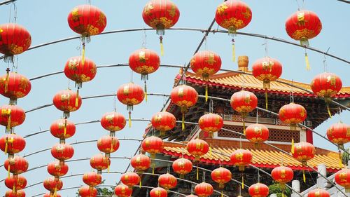 Low angle view of lanterns hanging against sky