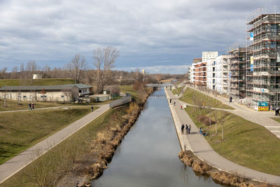 Canal amidst buildings in city against sky