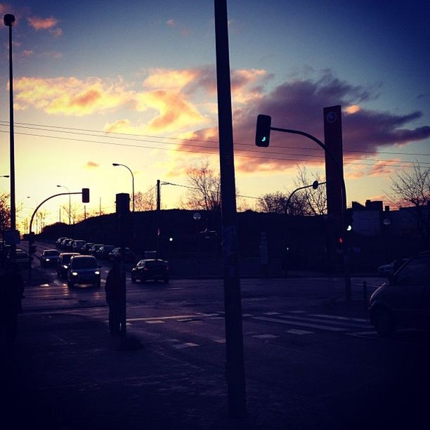 sunset, sky, transportation, land vehicle, car, street light, mode of transport, cloud - sky, street, silhouette, road, orange color, city, cloud, built structure, building exterior, architecture, cloudy, city street, dusk