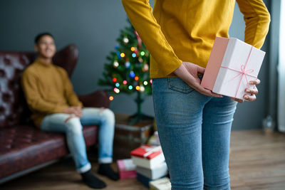 Midsection of couple holding christmas tree