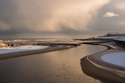 Scenic view of beach against sky during sunset