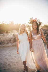 Friends standing at beach against sky