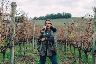 Portrait of young woman standing on field