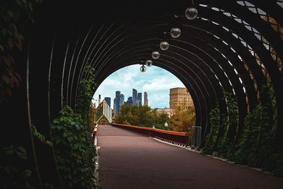 Arch bridge in city against sky