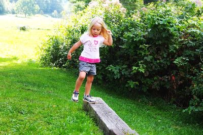 Full length portrait of smiling girl on grass