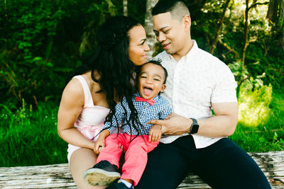 Cropped straight on portrait of a smiling family with a baby boy