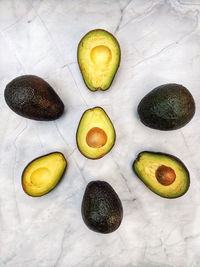 Fresh avocado with herbs and lemons lies on the table on white background. flat lay. top view.