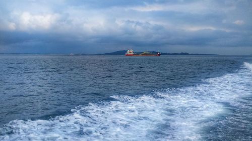 Scenic view of boat sailing in sea against sky