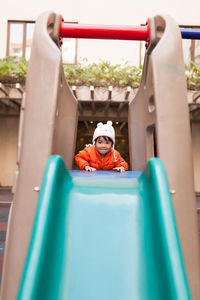 Portrait of girl on slide at playground