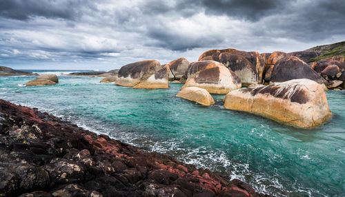 Rocks on sea shore against sky