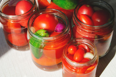 The process of canning tomatoes and cucumbers for the winter, pickled vegetables in glass jars 