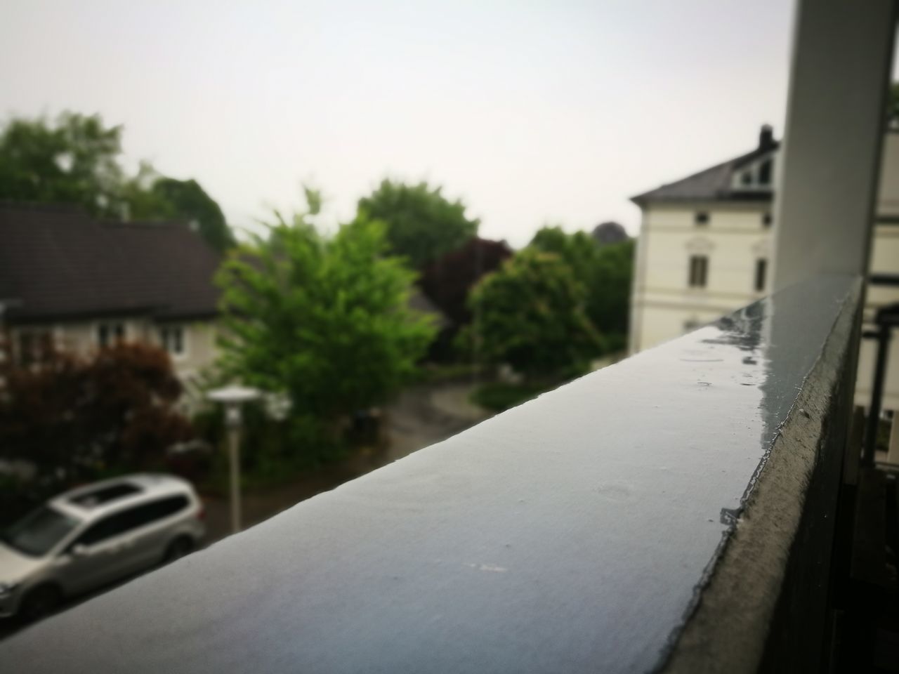 CLOSE-UP OF ROAD BY HOUSES AGAINST SKY