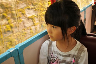 High angle view of girl looking through window