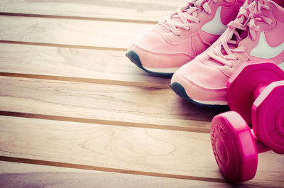 Shoes and dumbbells on wooden floor