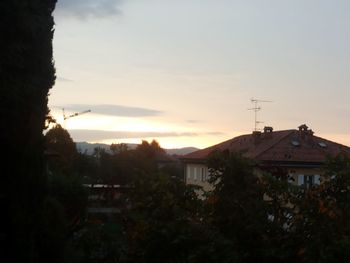 Houses in town against cloudy sky