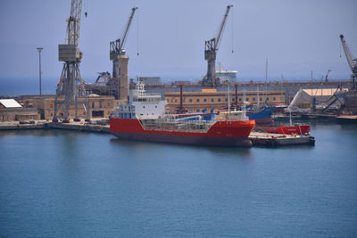 Sailboats in harbor against sky