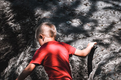 Midsection of boy with water at shore