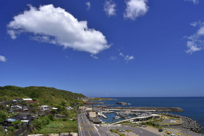 High angle view of road by sea against blue sky