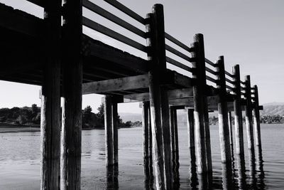 Wooden pier on sea against clear sky