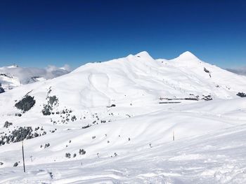 Scenic view of snowcapped mountains against clear blue sky