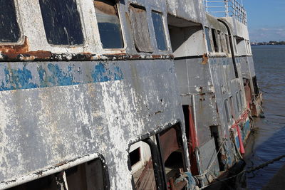 Low angle view of abandoned boat against sea