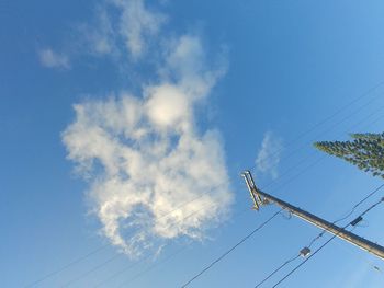 Low angle view of electricity pylon against blue sky