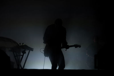 Silhouette man playing guitar