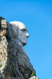 Low angle view of statue against clear blue sky