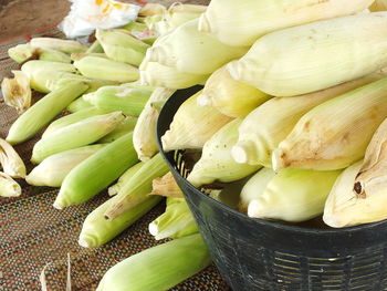 High angle view of fruits and leaves in basket for sale