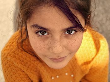 Close-up high angle portrait of smiling girl with freckles