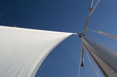 Low angle view of sailboat against clear blue sky