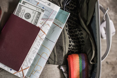 Close-up of passport on map by various objects in luggage