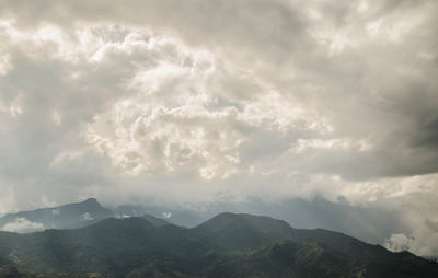 Scenic view of mountains against storm clouds