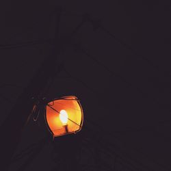 Low angle view of lit lamp in the dark