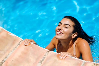 High angle view of young woman with eyes closed in swimming pool