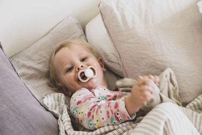 Smiling toddler girl in bed