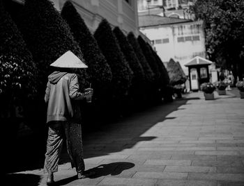 Rear view of man standing on footpath