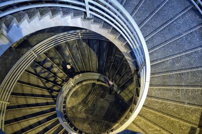 Directly above shot of young woman standing on spiral staircase