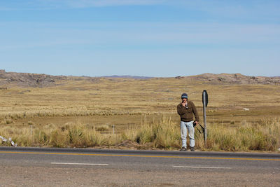 Man standing on road against landscape