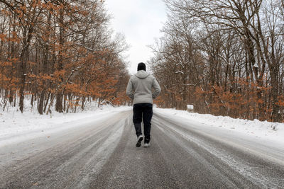 Rear view of man walking on road