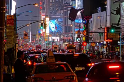 Cars on city street at times square during night