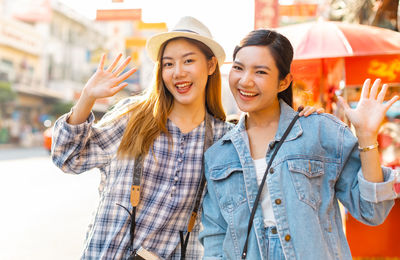 Portrait of smiling young women standing in city