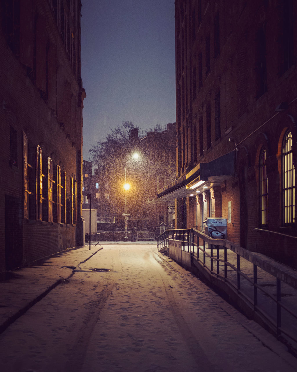 STREET AMIDST BUILDINGS IN CITY AT NIGHT DURING WINTER